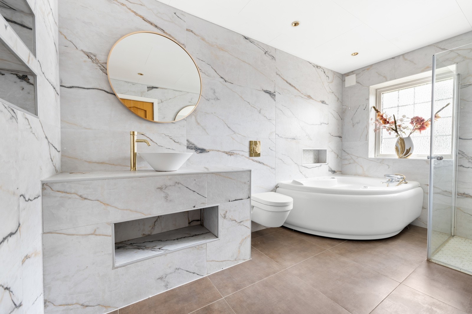 Badet har innmurt benk med skålservant, vegmontert wx, dusjhjørne og badekar. Galleribilde