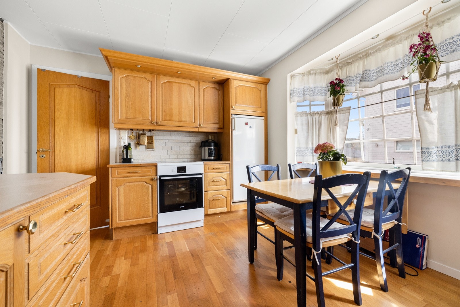 Eldre kjøkken med spiseplass i tilknytning til stuen. Galleribilde