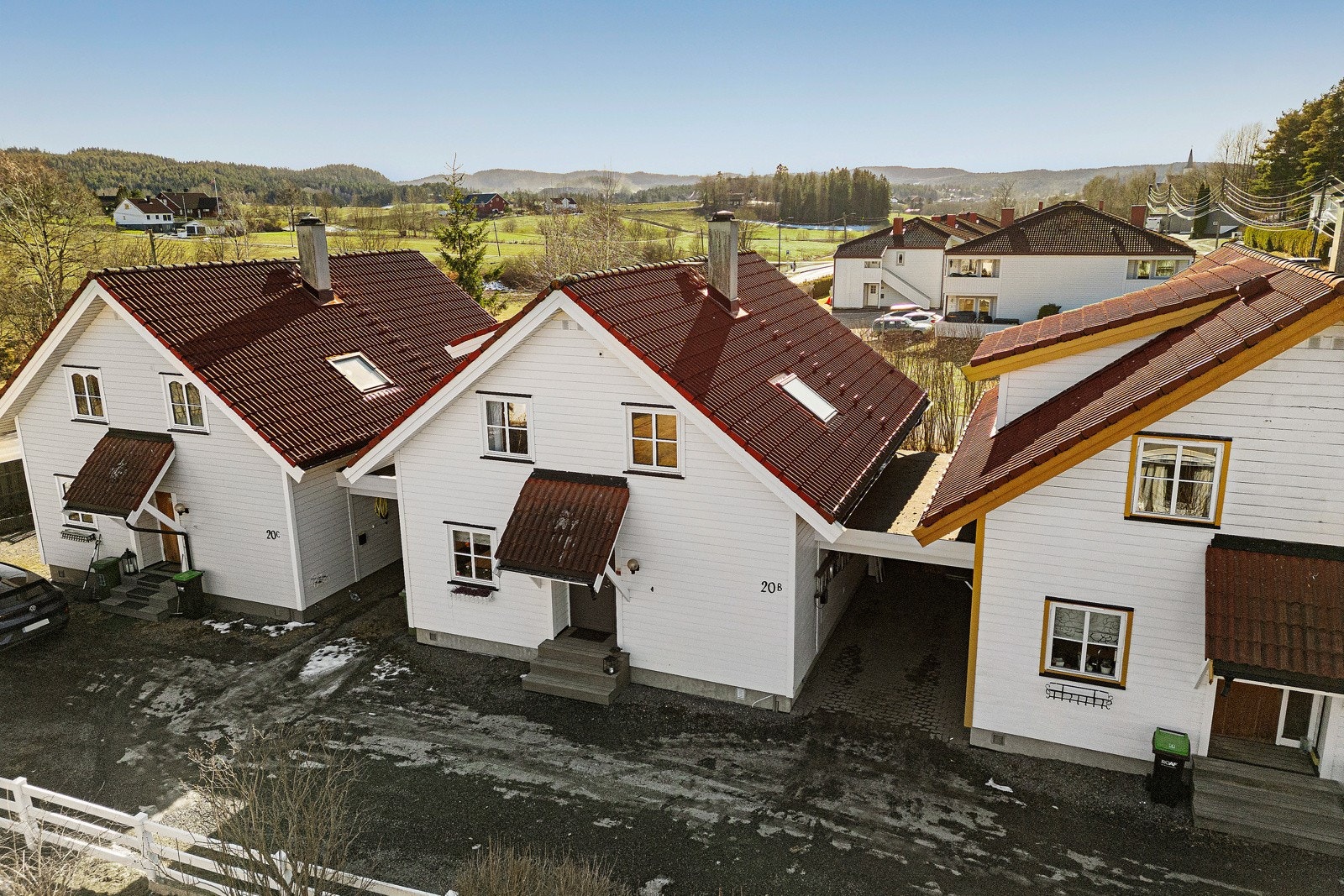 Carport ved siden av inngangspartiet med el.bil-lader. Bil nr. 2 kan parkeres langs gjerdet foran huset Galleribilde