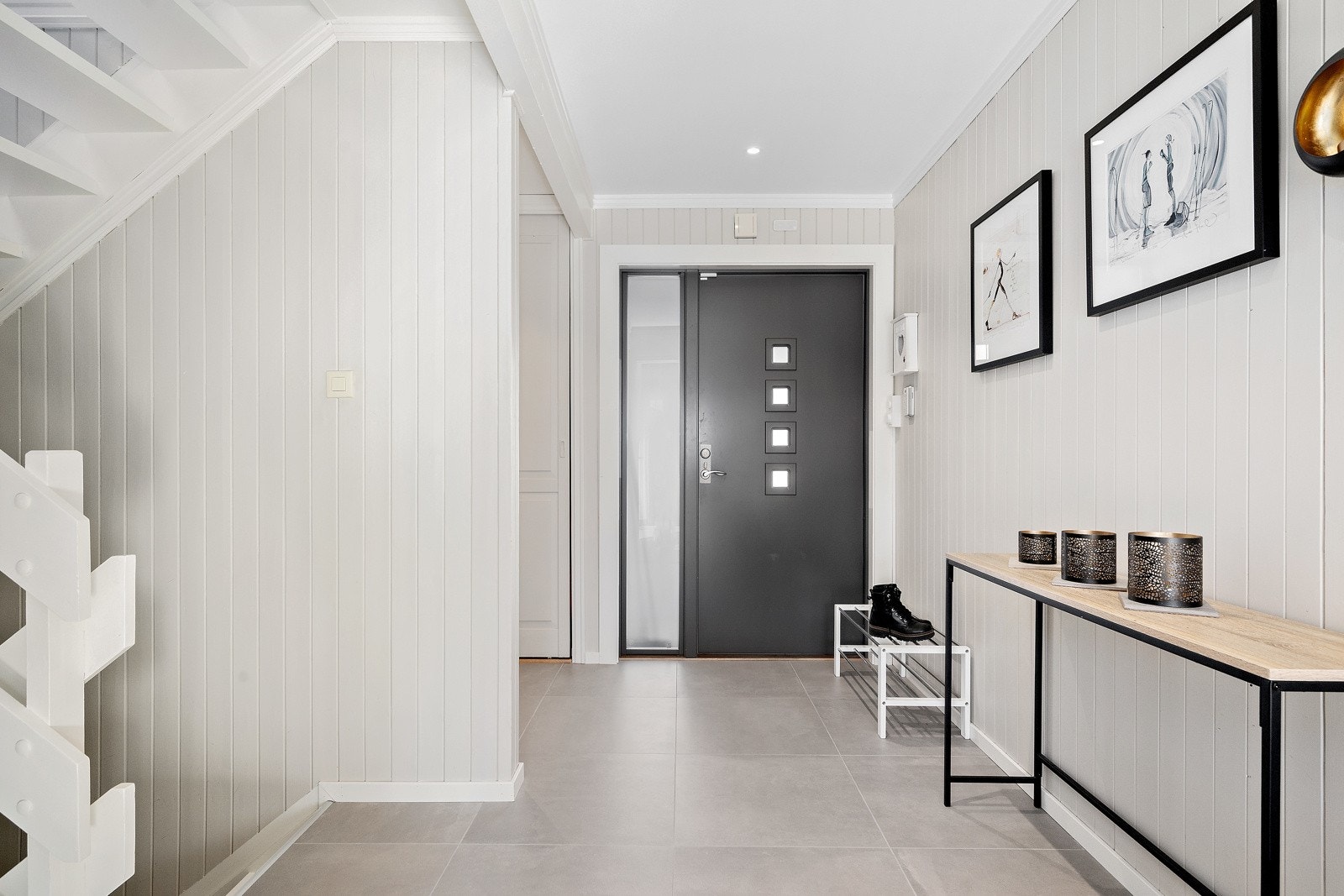 Hallen er lys, romslig og gir et godt førsteinntrykk av huset. Ytterdøren ble byttet i 2023. Galleribilde