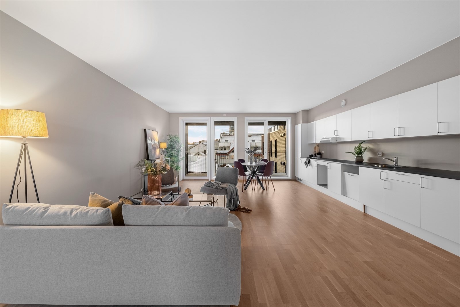 Stor og åpen stuekjøkken, med store vinduer og utgang til balkong. Galleribilde