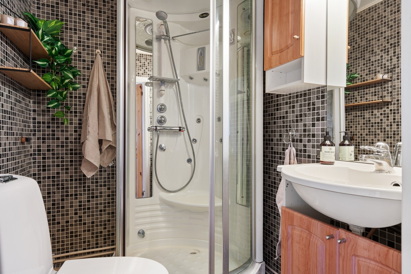 Bad med dusjkabinett, wc og servant i innredning. Galleribilde