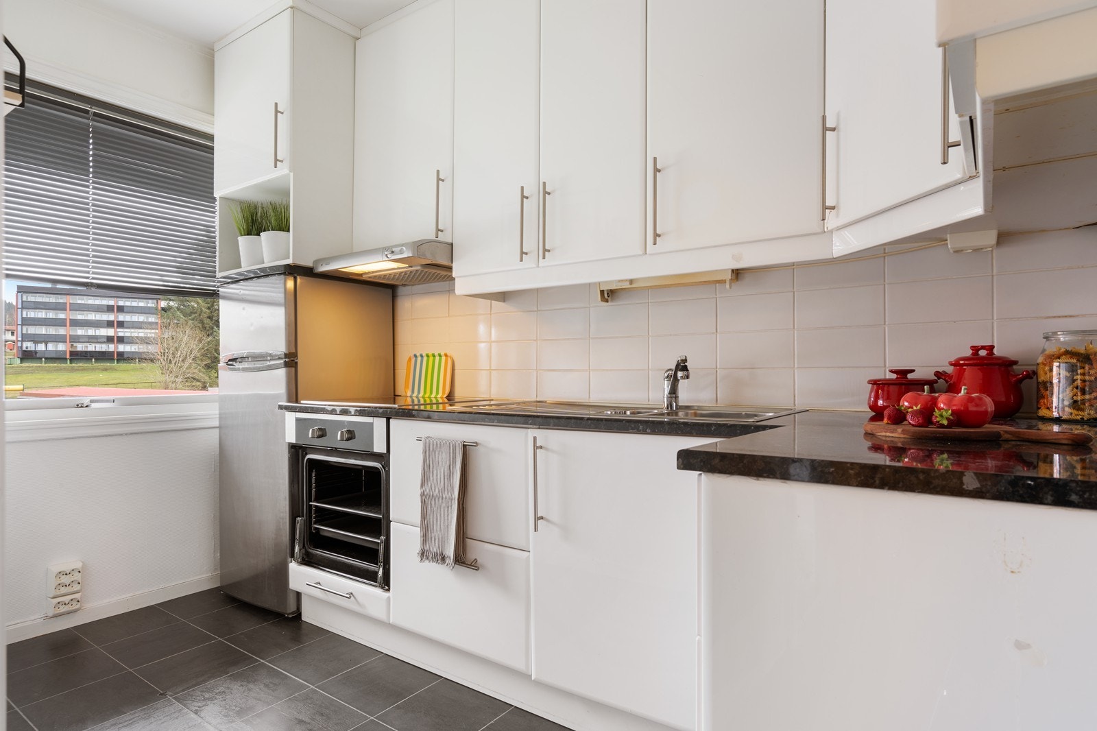 Lyst kjøkken med god med skap og benkeplass. Galleribilde