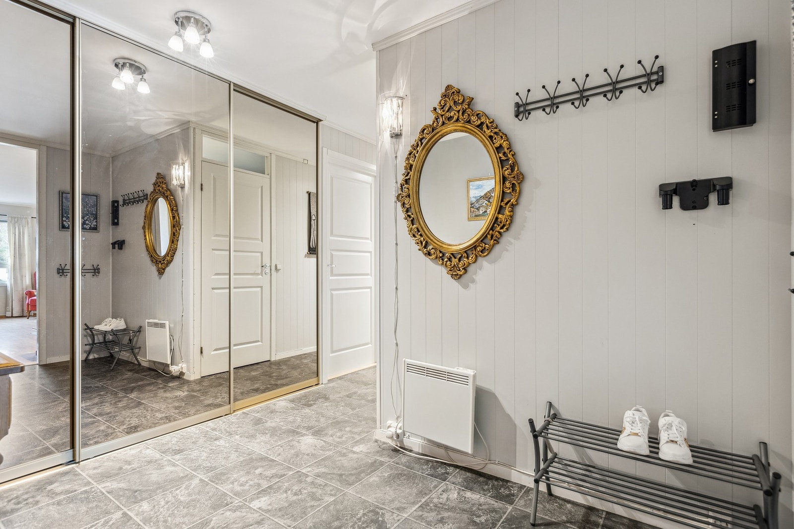 Den romslige gangen har en stor skyvedørsgarderobe med god oppbevaringsplass, og speilfronter som bidrar til en luftig og lys romfølelse. Galleribilde