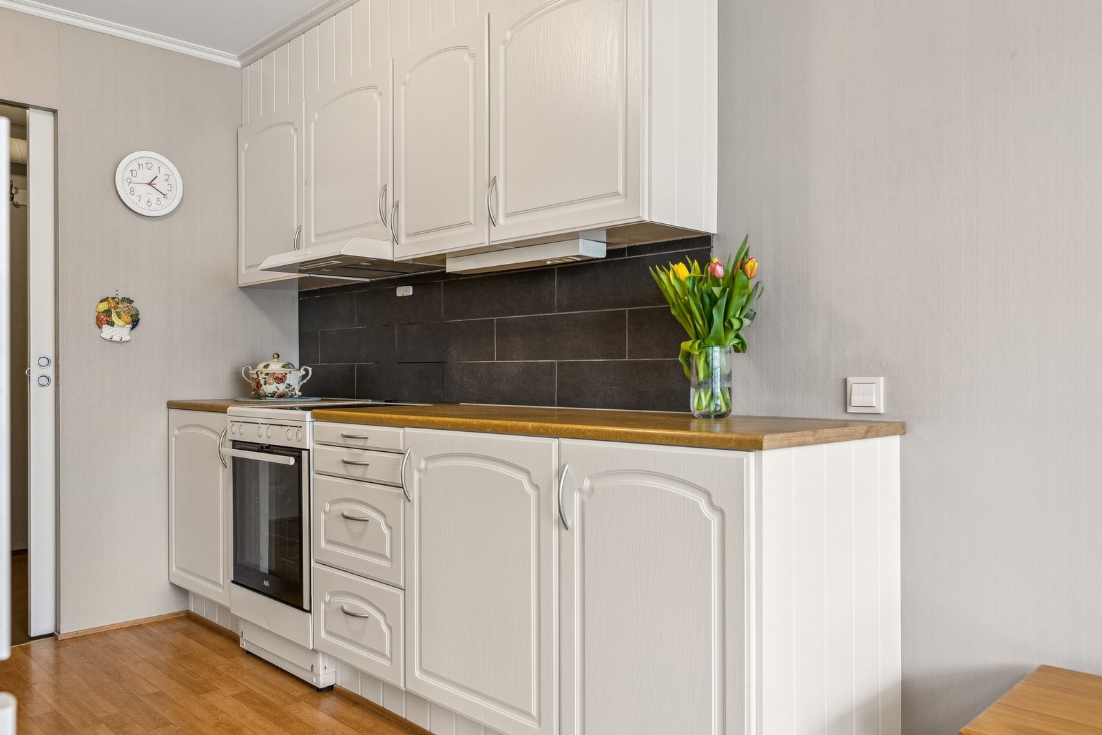 Kjøkkenbenken er flislagt, noe som både gir et stilfullt preg og gjør det enkelt å holde rent. Galleribilde