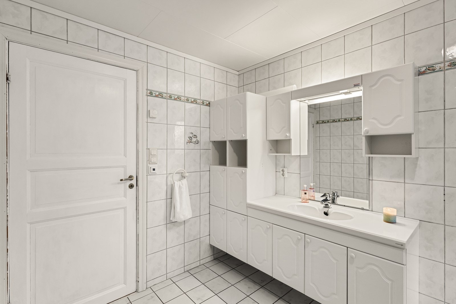 Badet er innredet med vegghengt toalett, servant med møblement og dusj med kabinett. Galleribilde