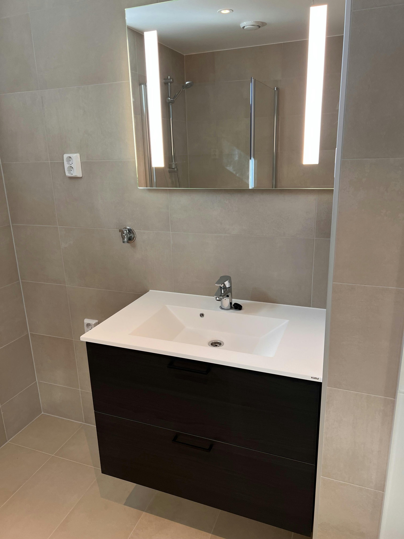 Moderne flislagt bad med gulvvarme og opplegg for vaskemaskin. Galleribilde