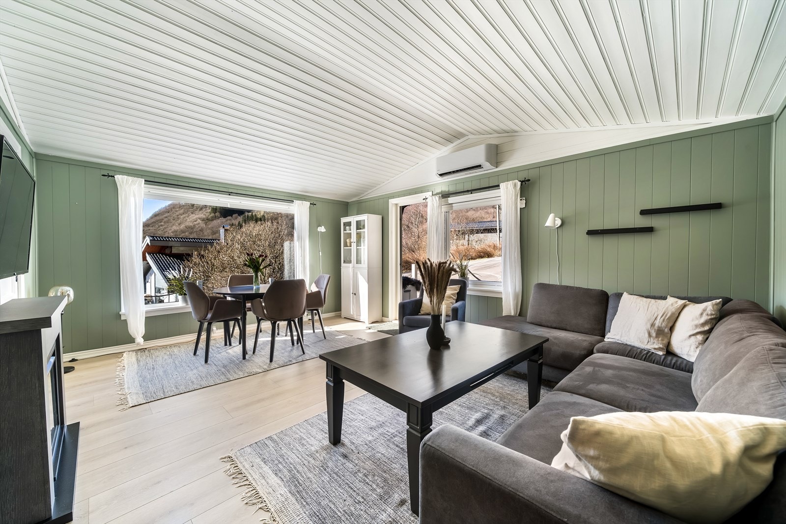 Stuens utforming gir rom for møblering i ulike soner. Utgang til terrasse. Galleribilde