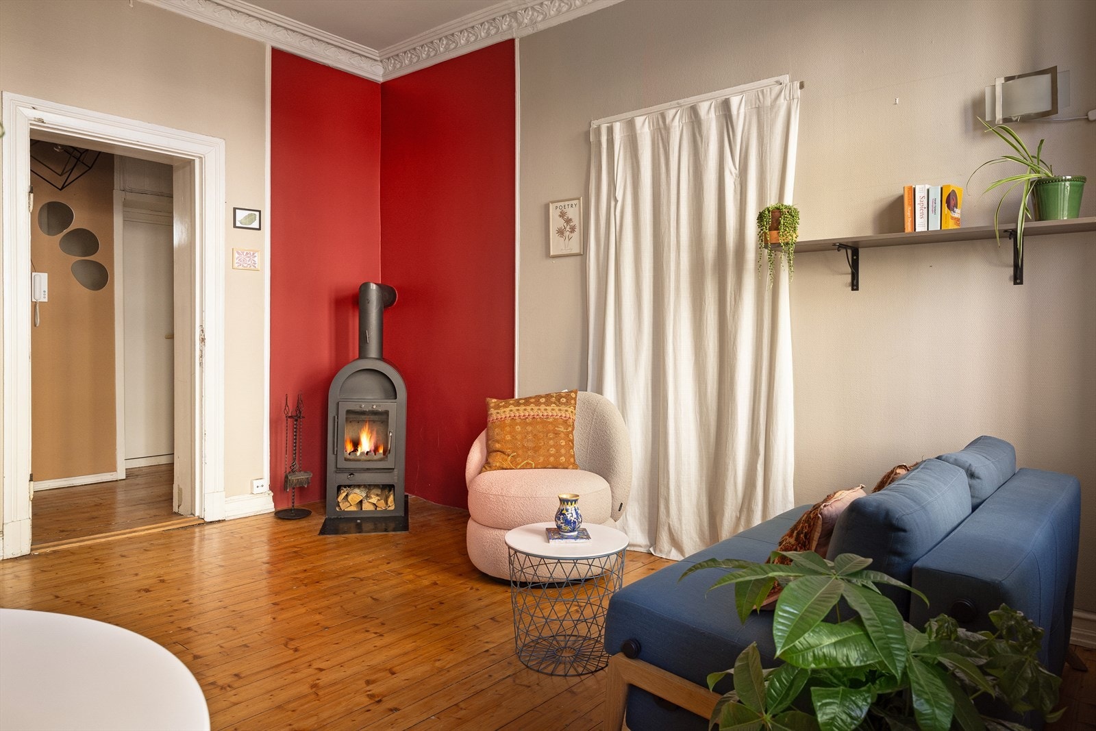 I hjørnet står det en pen peisovn som varmer godt på kjøligere dager og bidrar til lavere strømregninger. Galleribilde