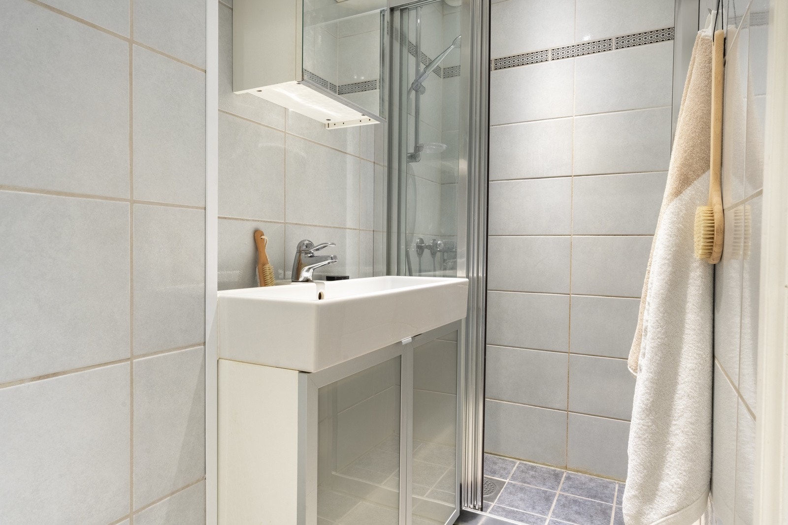 Badet er helfliset og har en slett malt himling. Det er selvfølgelig varme i gulv. Galleribilde