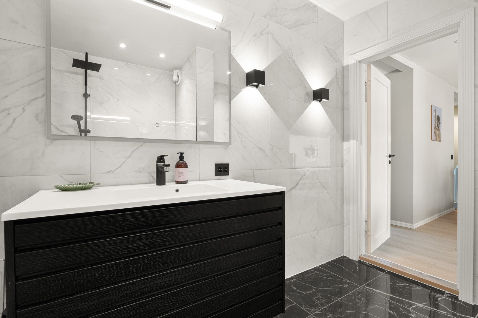 Lekkert baderom fra 2019 med marmorpreg og sorte detaljer. Galleribilde