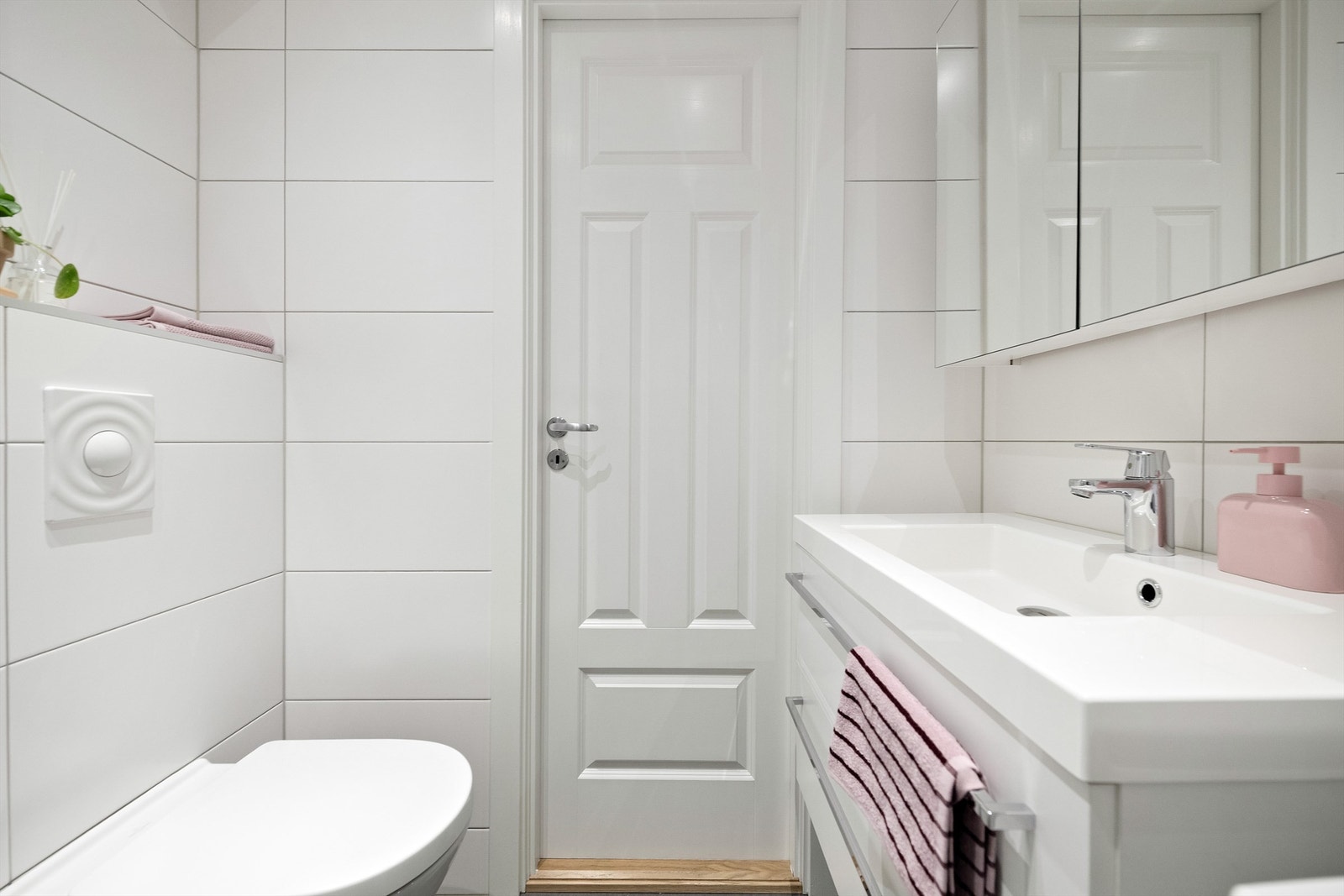 Rommet er innredet med baderomsinnredning, vegghengt toalett, dusjhjørne og opplegg for vaskemaskin Galleribilde