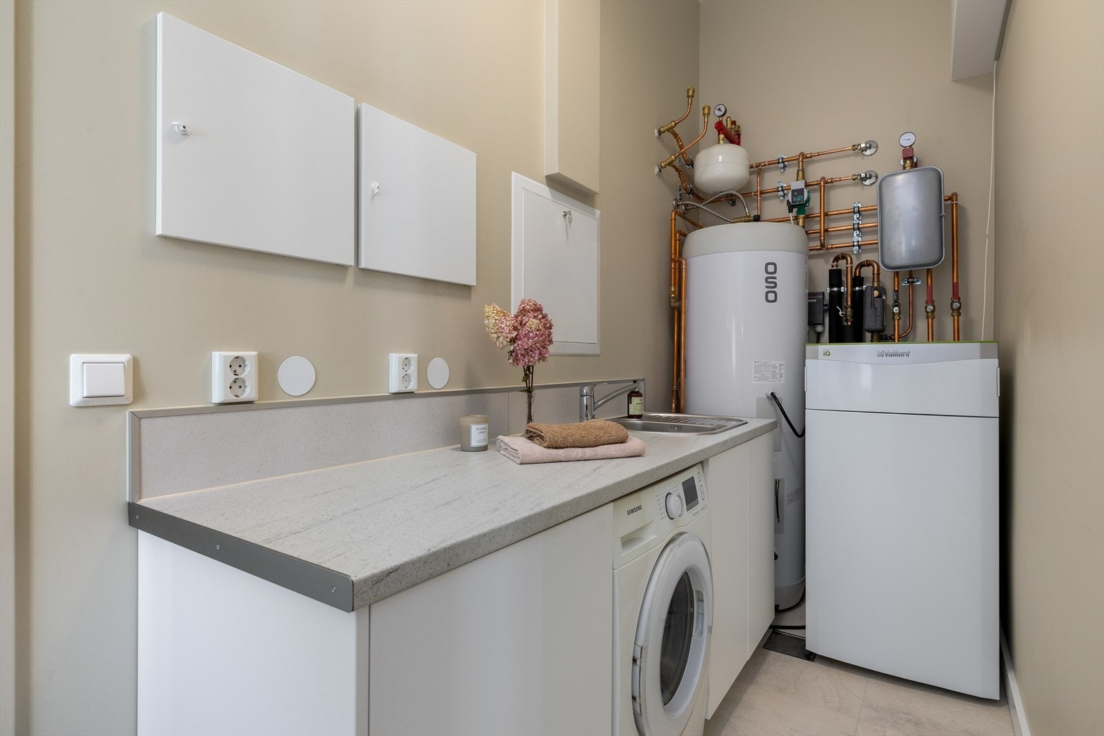 Vaskerommet/teknisk rom er innredet med en praktisk og funksjonell løsning, inkludert en romslig arbeidsbenk og godt med oppbevaringsplass. Galleribilde