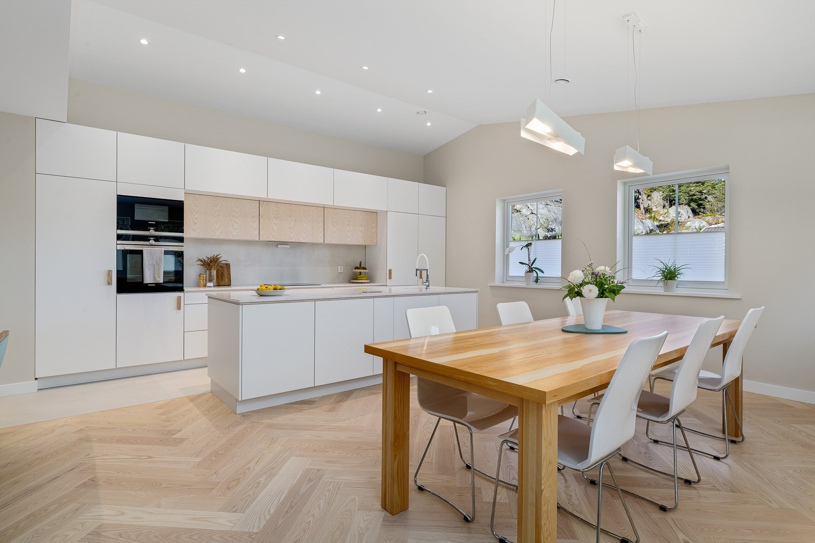 Lekkert og moderne kjøkken med åpen løsning mot stuen, som skaper en lys og sosial atmosfære. Galleribilde