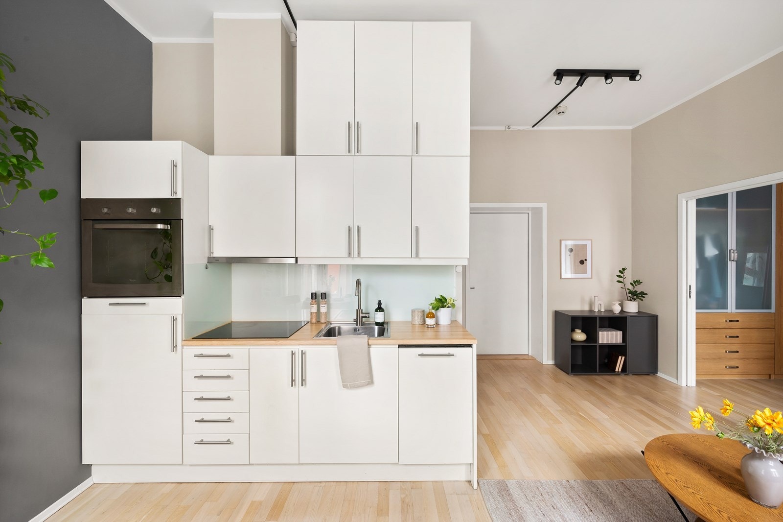 Innredning med mekanisk avtrekksvifte over stekesonen. Integrerte hvitevarer består av kjøleskap, stekeovn og platetopp. Galleribilde