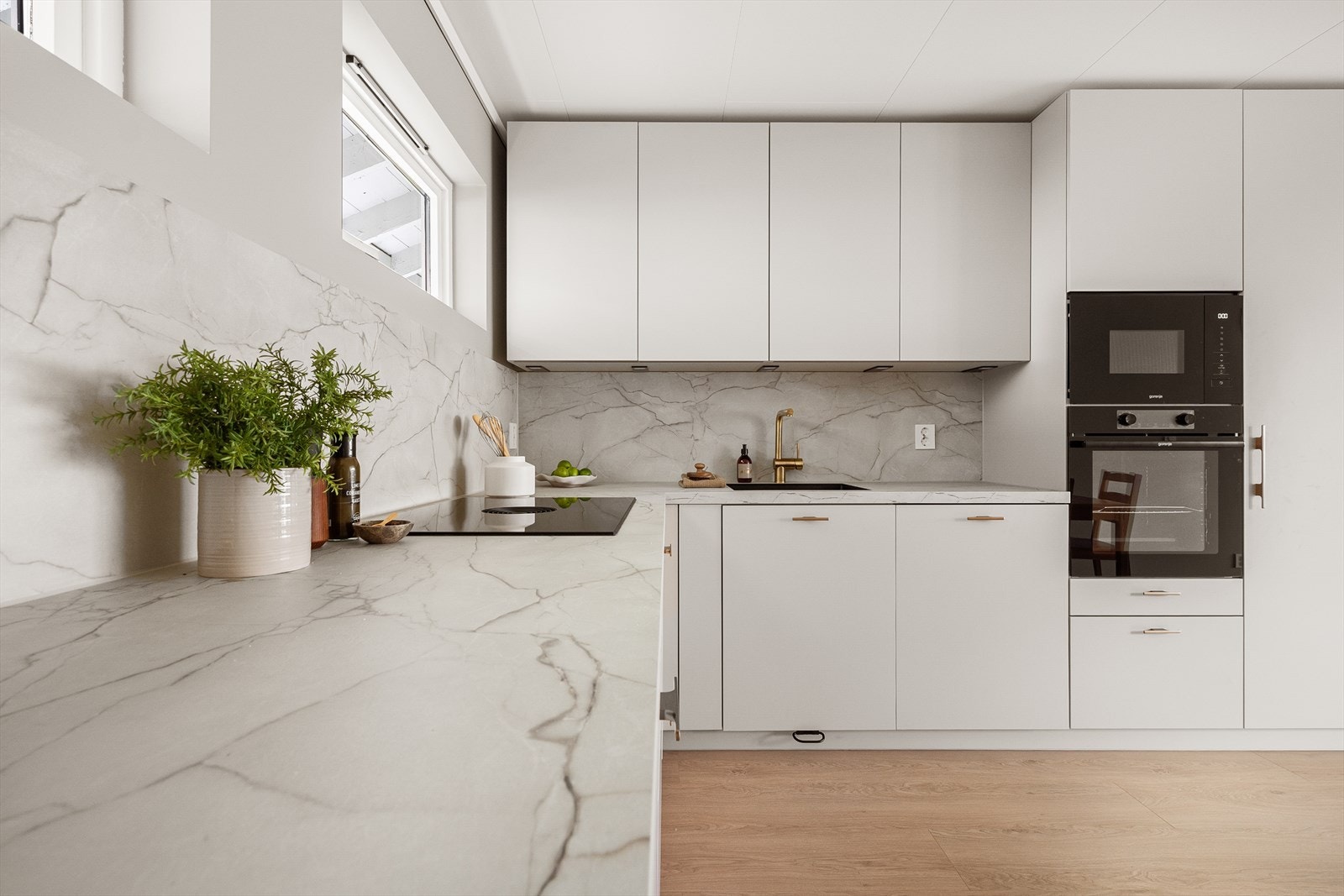 Pent kjøkken med glatte fronter og integrerte hvitevarer Galleribilde