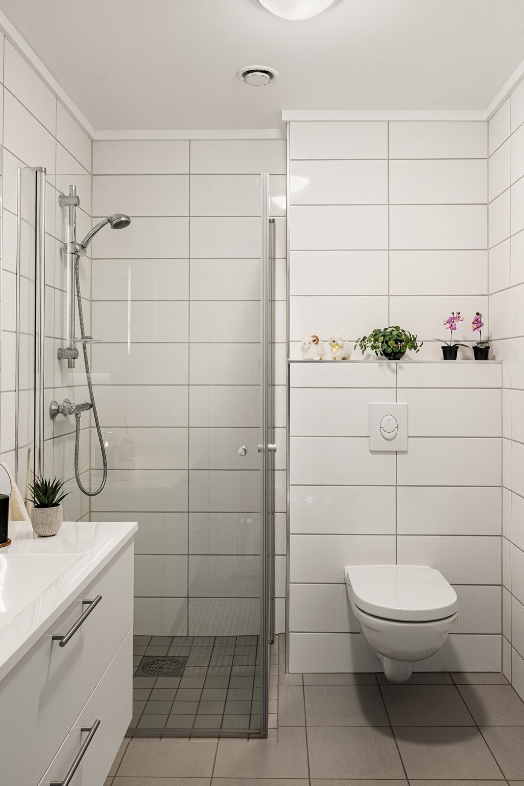 Videre er badet utstyrt med dusjhjørne med innfellbar dusjvegger, vegghengt toalett. Galleribilde