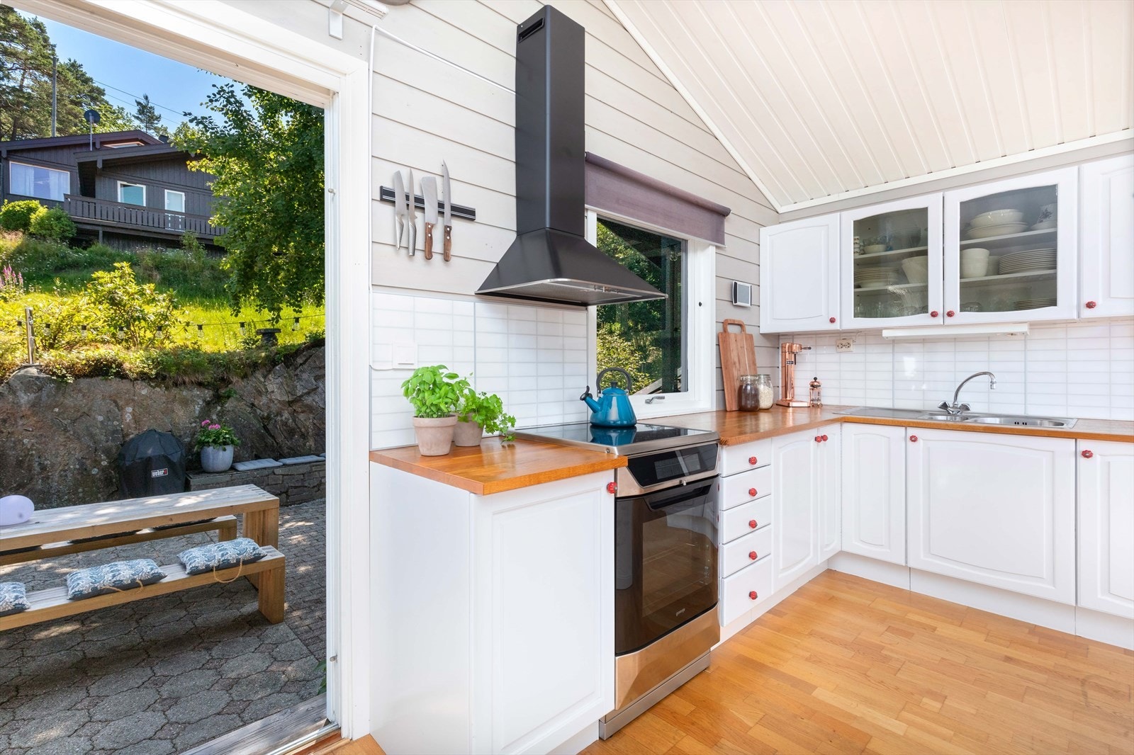 Lys og innbydende kjøkken med direkte utgang til solrik uteplass. Perfekt for hyggelige måltider i naturskjønne omgivelser. Galleribilde