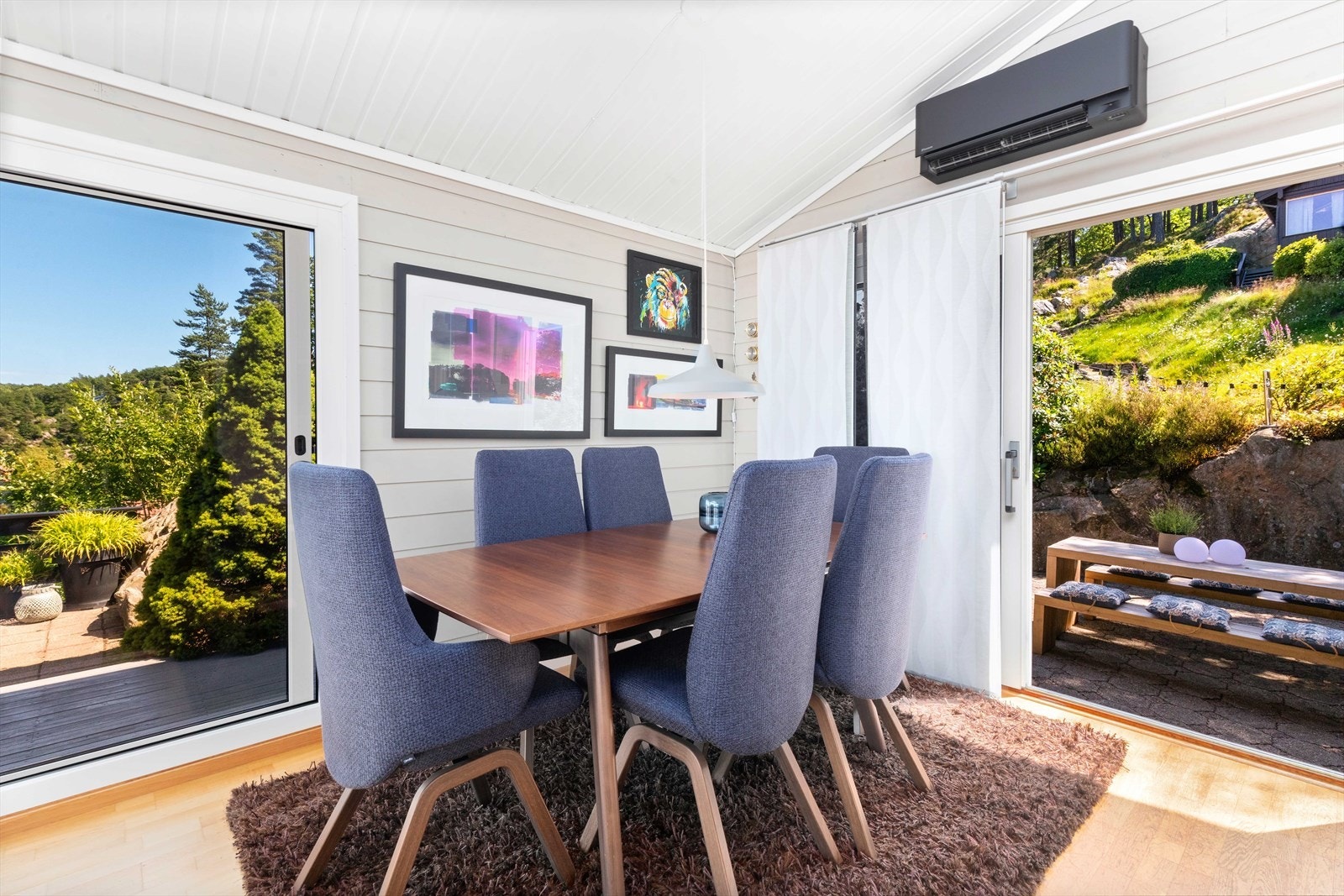 Moderne spisestue med store vinduer som gir mye naturlig lys og vakker utsikt til frodig hage og vakker natur. Galleribilde