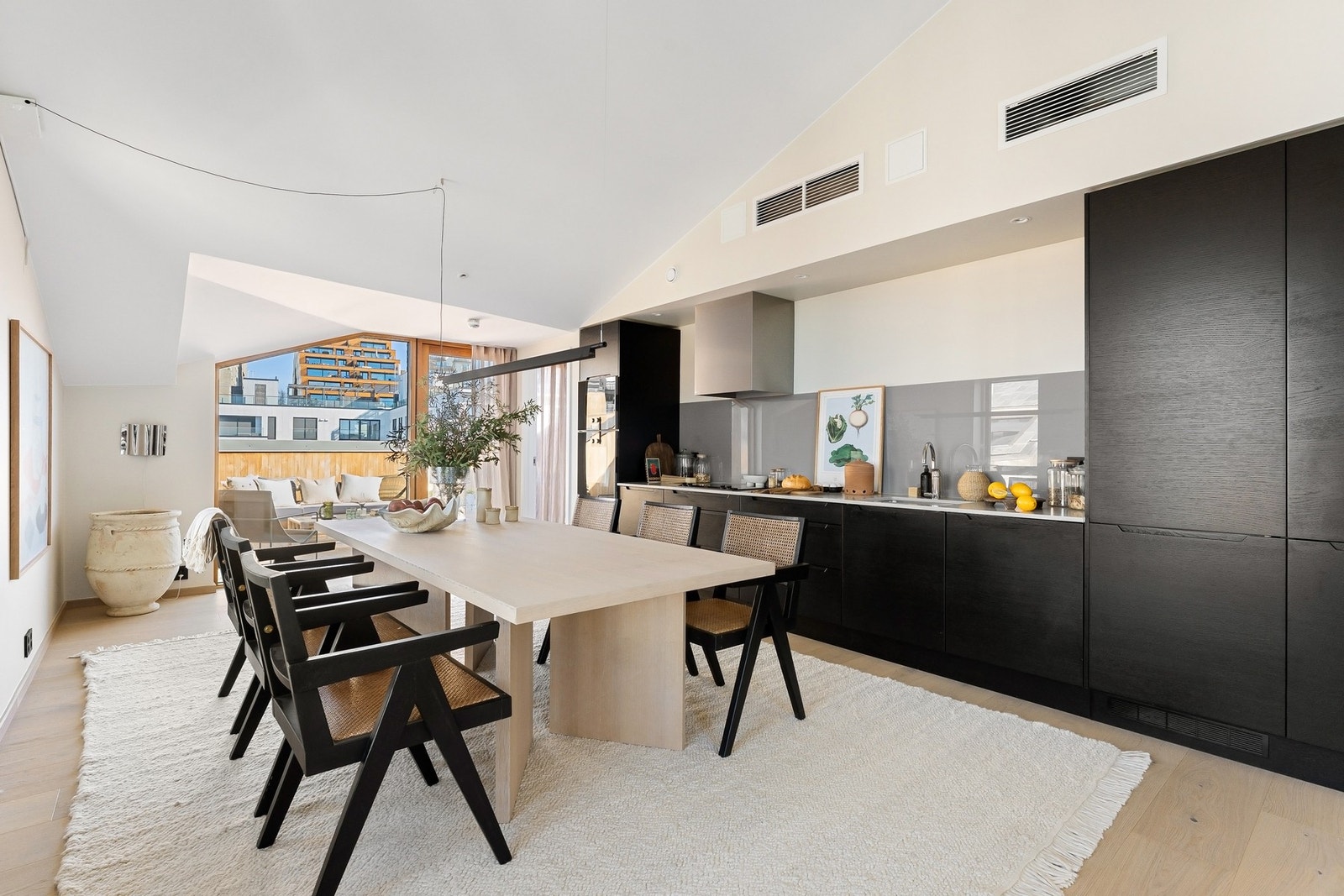 HTH-kjøkkenet er stilrent innredet med glatte fronter i mørk utførelse, elegant kombinert med en eksklusiv benkeplate i steinkompositt. Galleribilde