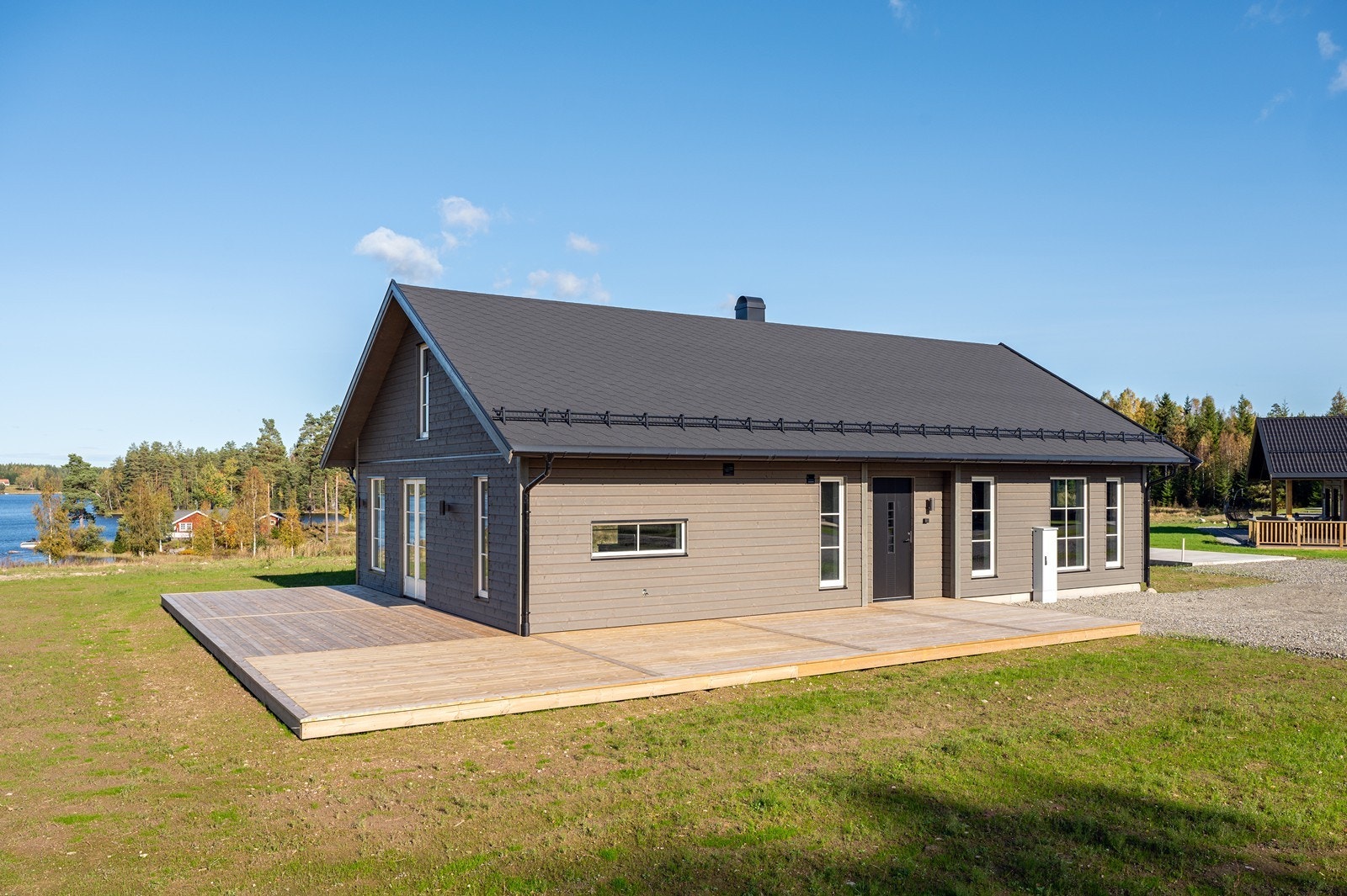 Stor terrasseplatting som strekker seg fra inngangspartiet og rundt med egen adkomst fra stuen. Galleribilde