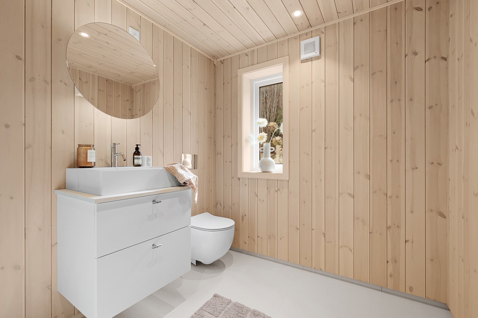 Badet er utstyrt med vegghengt toalett, servant med underskap og egen dusjsone. Galleribilde