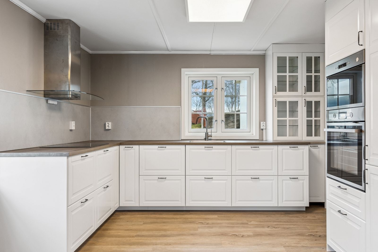 Lyst og pent kjøkken med integrerte hvitevarer - rikelig skap-og benkeplass Galleribilde