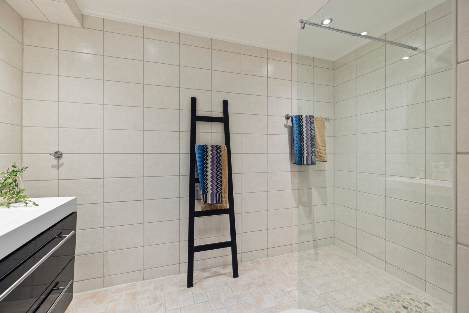 Badet er romslig med downlights og lyse fliser Galleribilde
