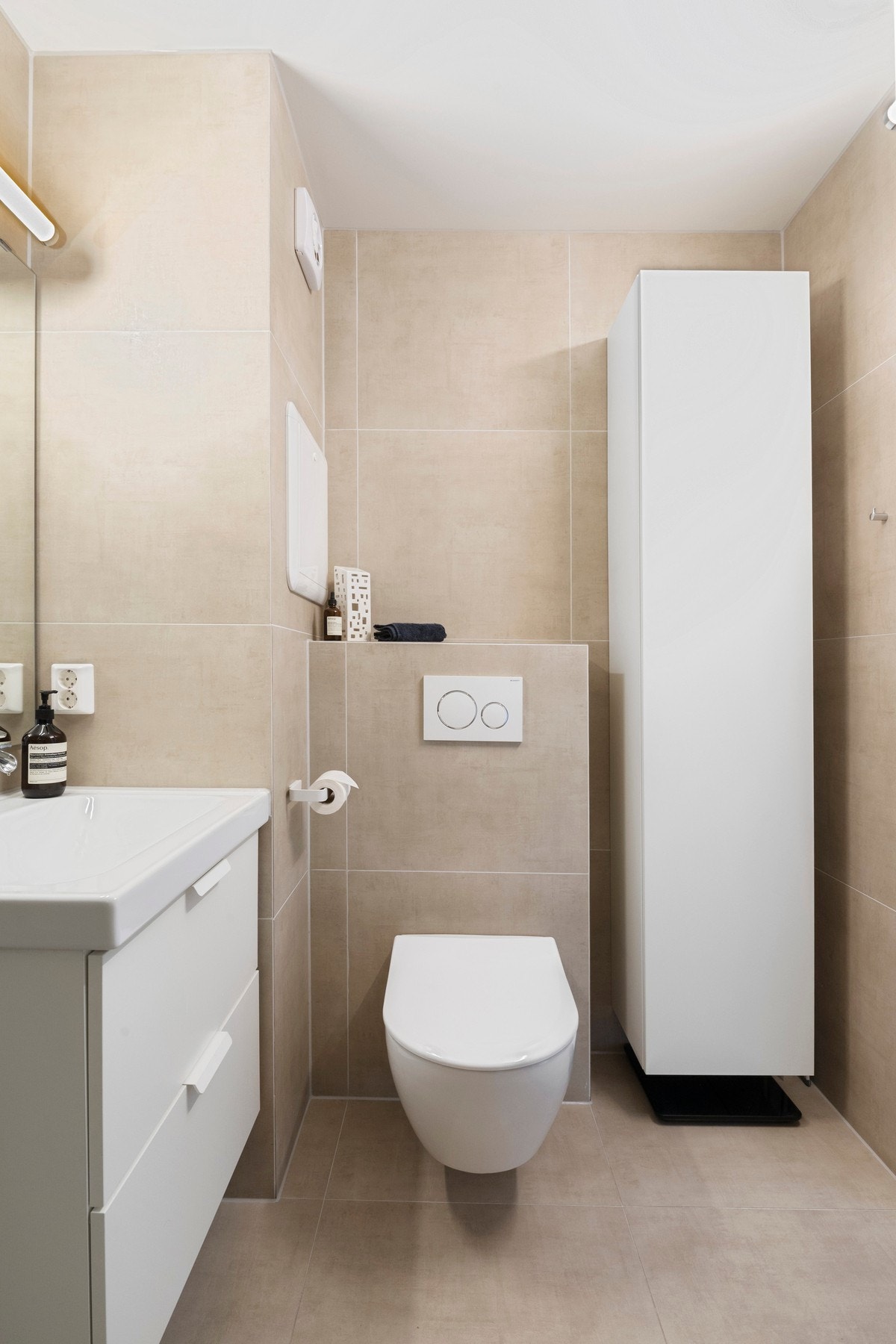 Baderommet har en lys og moderne innredning og opplegg for vaskemaskin Galleribilde