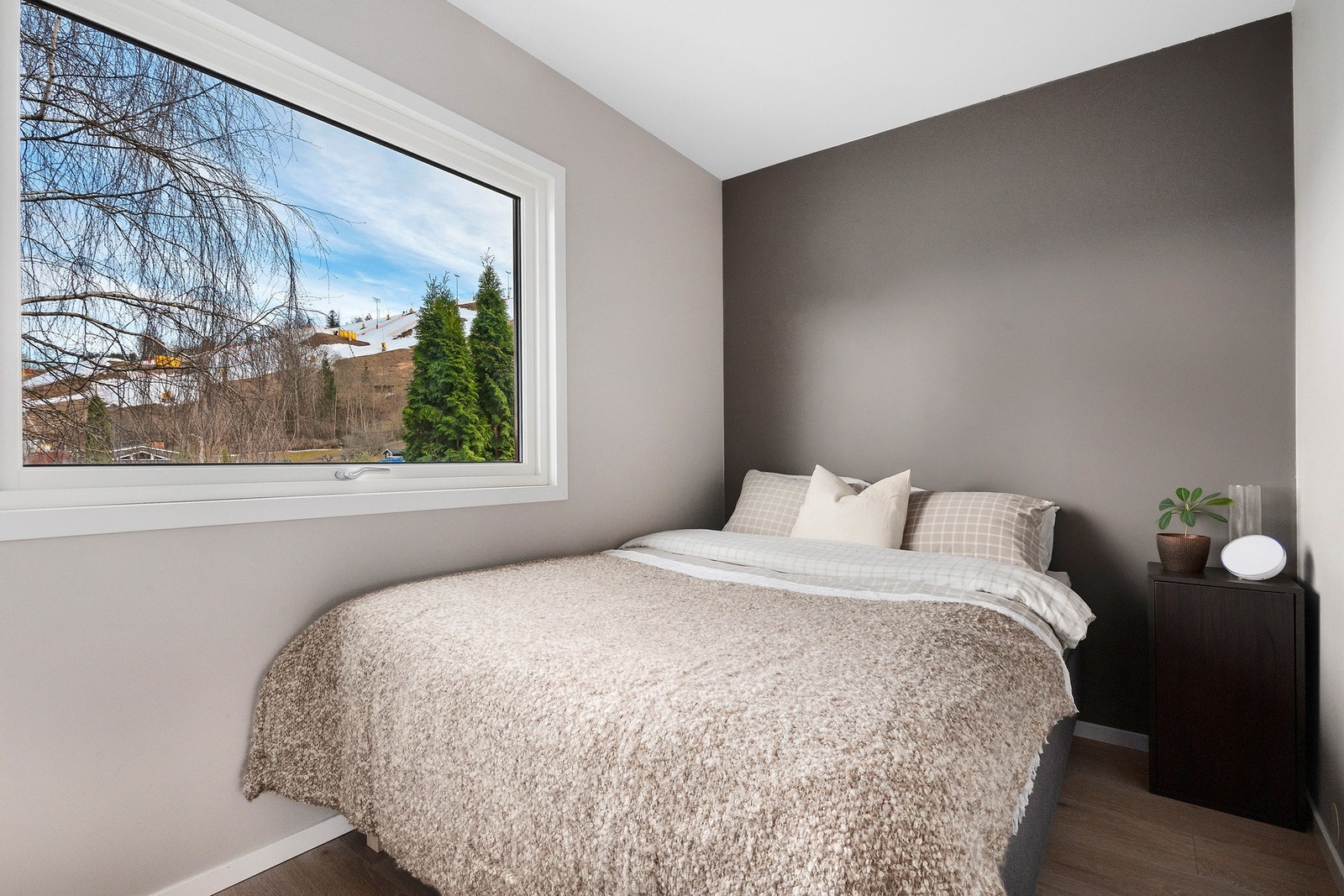 Romslig soverom med god plass til stor seng og nattbord Galleribilde