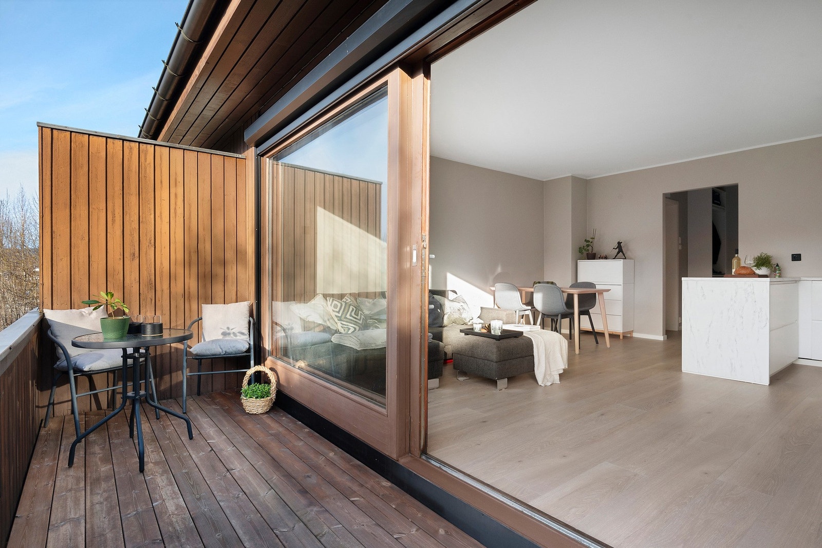Den store skyvedøren ut til balkongen gjør det enkelt å sammenslå balkong og oppholdsrom til ett stort bruksområde på varme sommerdager Galleribilde