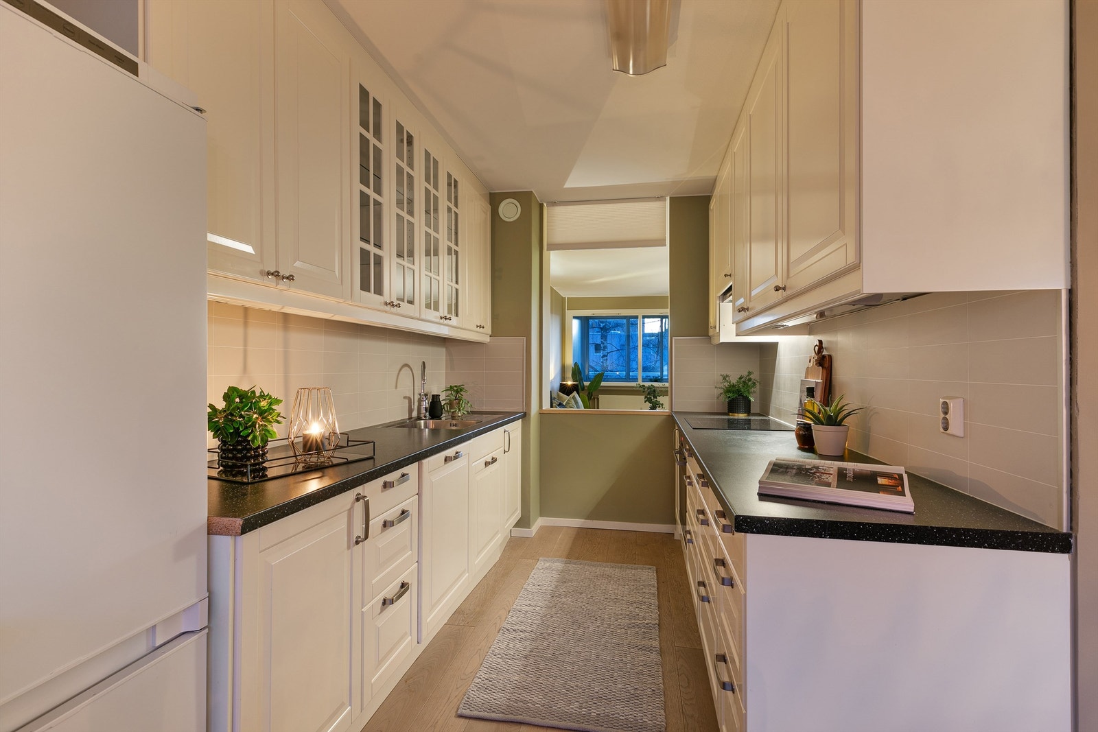 Kjøkkenet har lyse, profilerte fronter og rikelig med oppbevaringsplass som bidrar til en praktisk og stilren kjøkkenløsning. Galleribilde