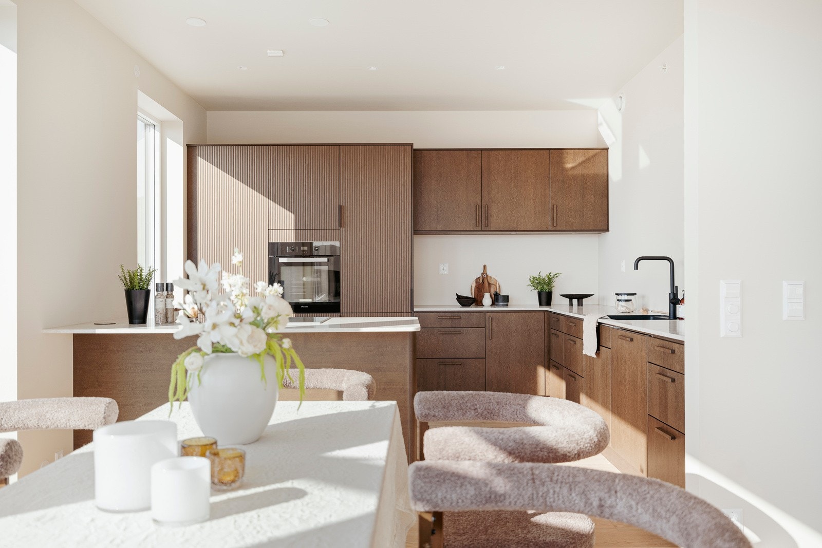 I delvis åpen løsning har man et stilrent kjøkken levert av kvalitetsleverandøren Sigdal, klart avgrenset fra deler av stuen. Galleribilde