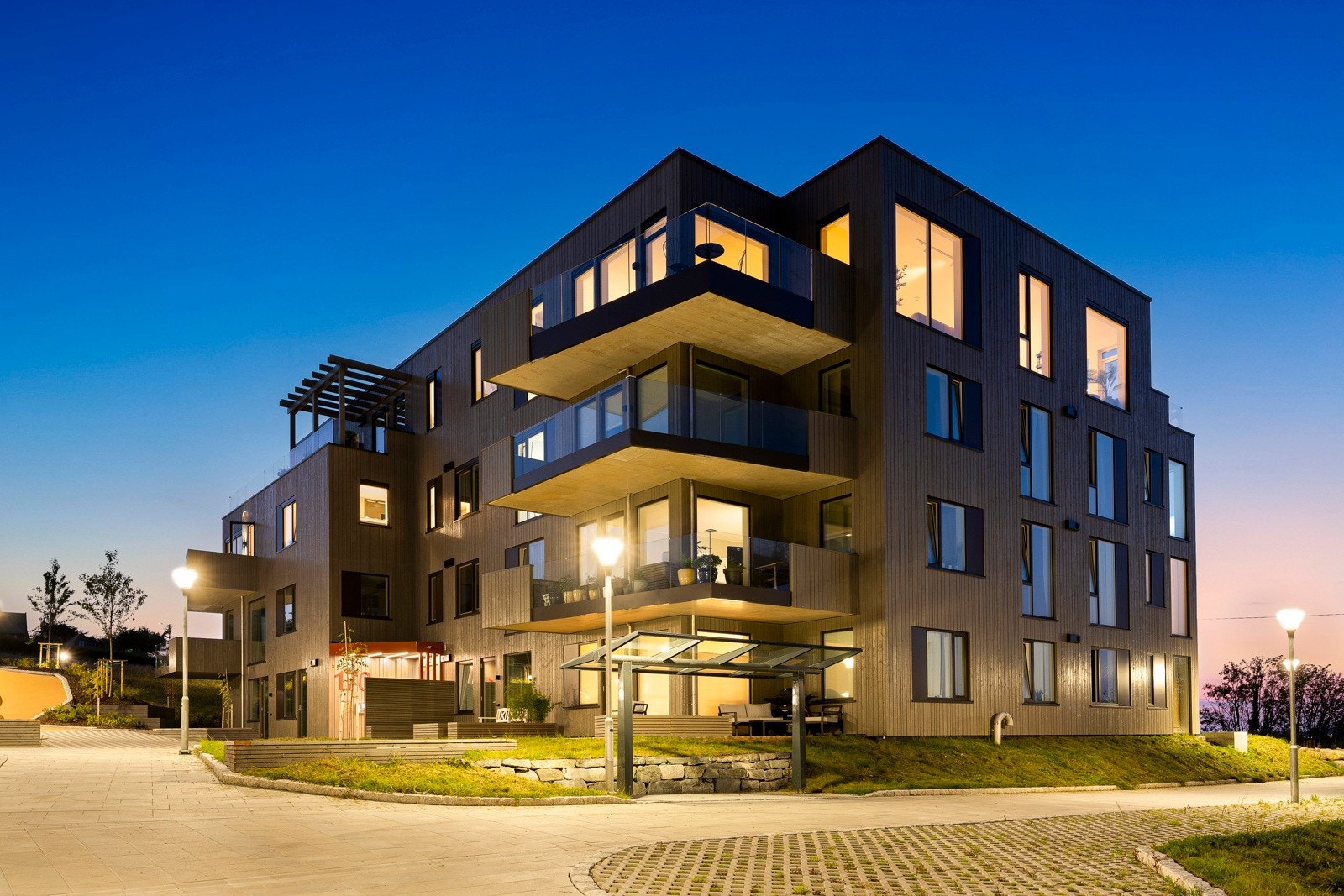 Arkitektene ønsket å skape en lun og god opplevelse utendørs, og har valgt en trefasade i varme naturfarger. Galleribilde