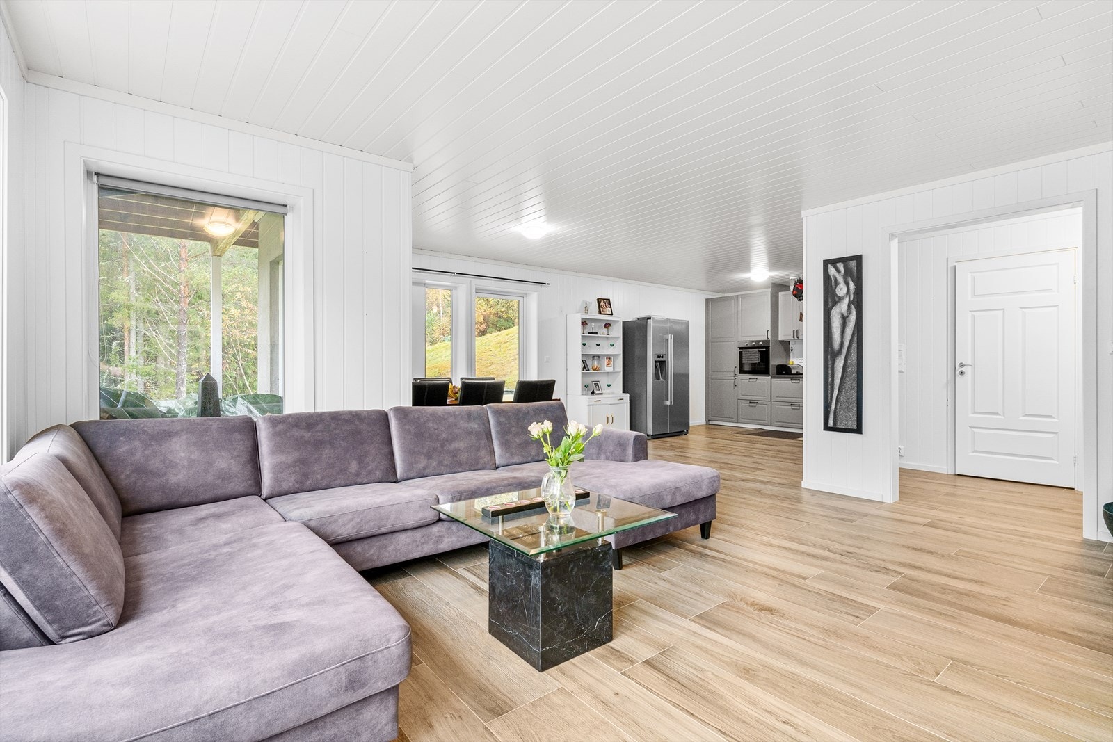 Stuen i underetasjen er tilnærmet lik med fliser på gulv og malt panel på vegg. Galleribilde