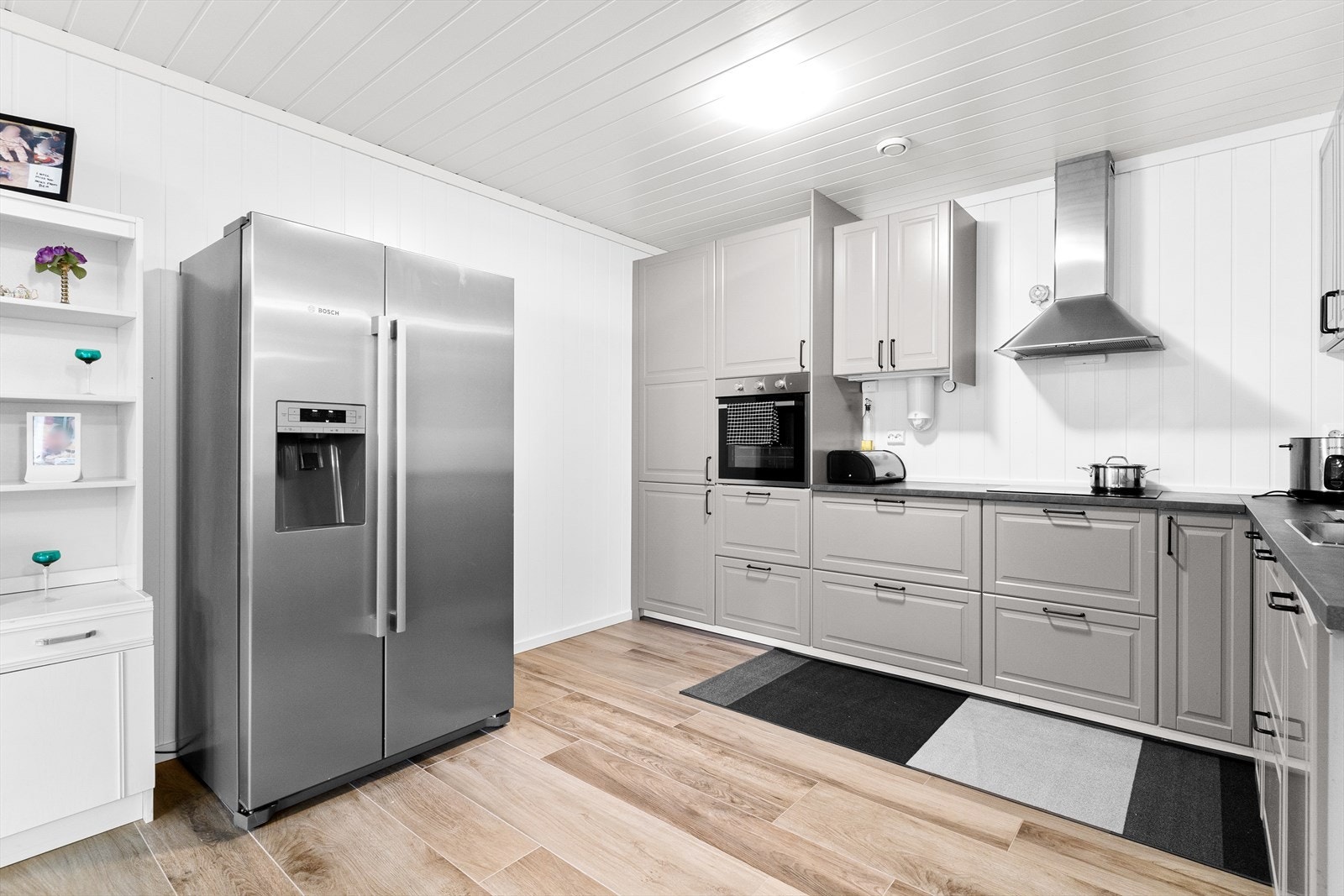 Kjøkkenet er utstyrt med integrerte hvitevarer som frittstående kjøl/fryseskap, oppvaskmaskin, induksjonstopp og stekeovn. Galleribilde