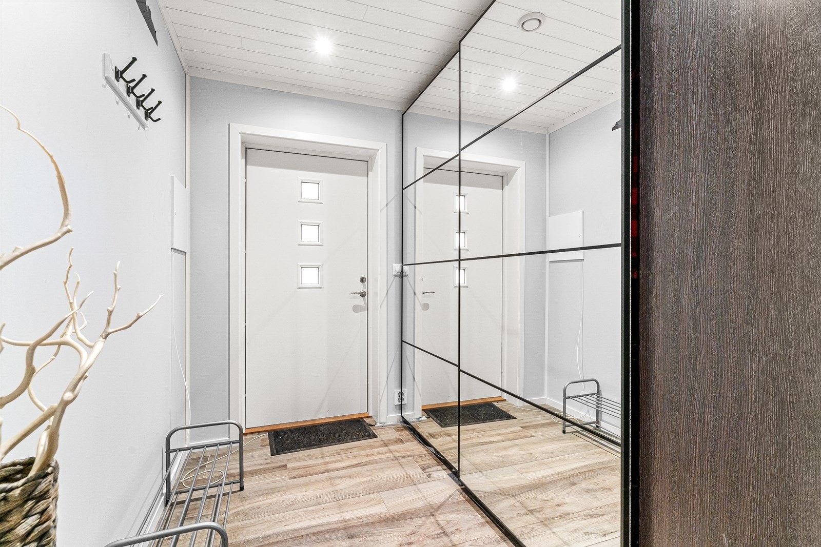 Lys og romslig, flislagt entré med vannbåren gulvvarme og downlights i tak hvor det også er god plass til å henge ifra seg yttertøyet i skyvedørsgarderobe. Galleribilde