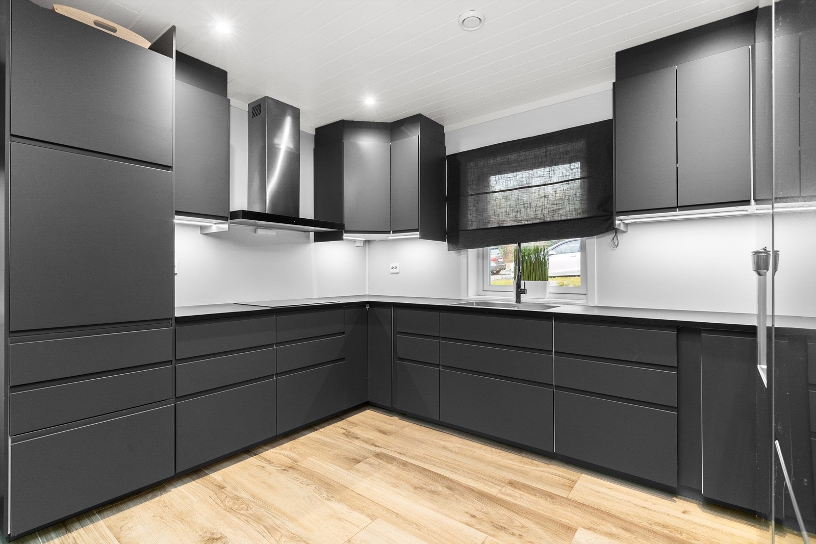 De slette overflatene og de gjennomførte detaljene fremhever kjøkkenets moderne estetikk. Galleribilde