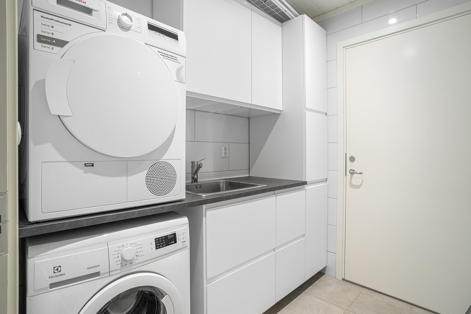 Vaskerommet har innredning med over- og underskap, benk med nedfelt servant kum samt opplegg for vaskemaskin og tørketrommel. Galleribilde