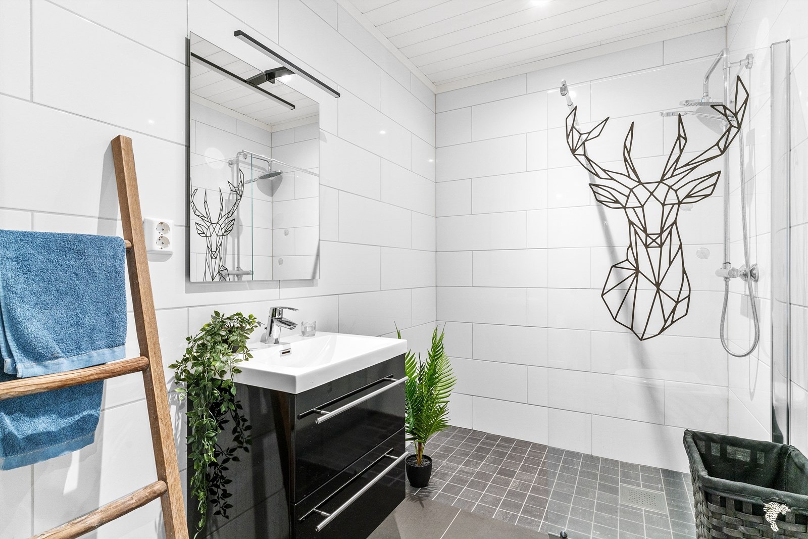 Det andre badet i 1.etasje har en enkel sort servantinnredning, speil med belysning, toalett og dusjsone. Galleribilde