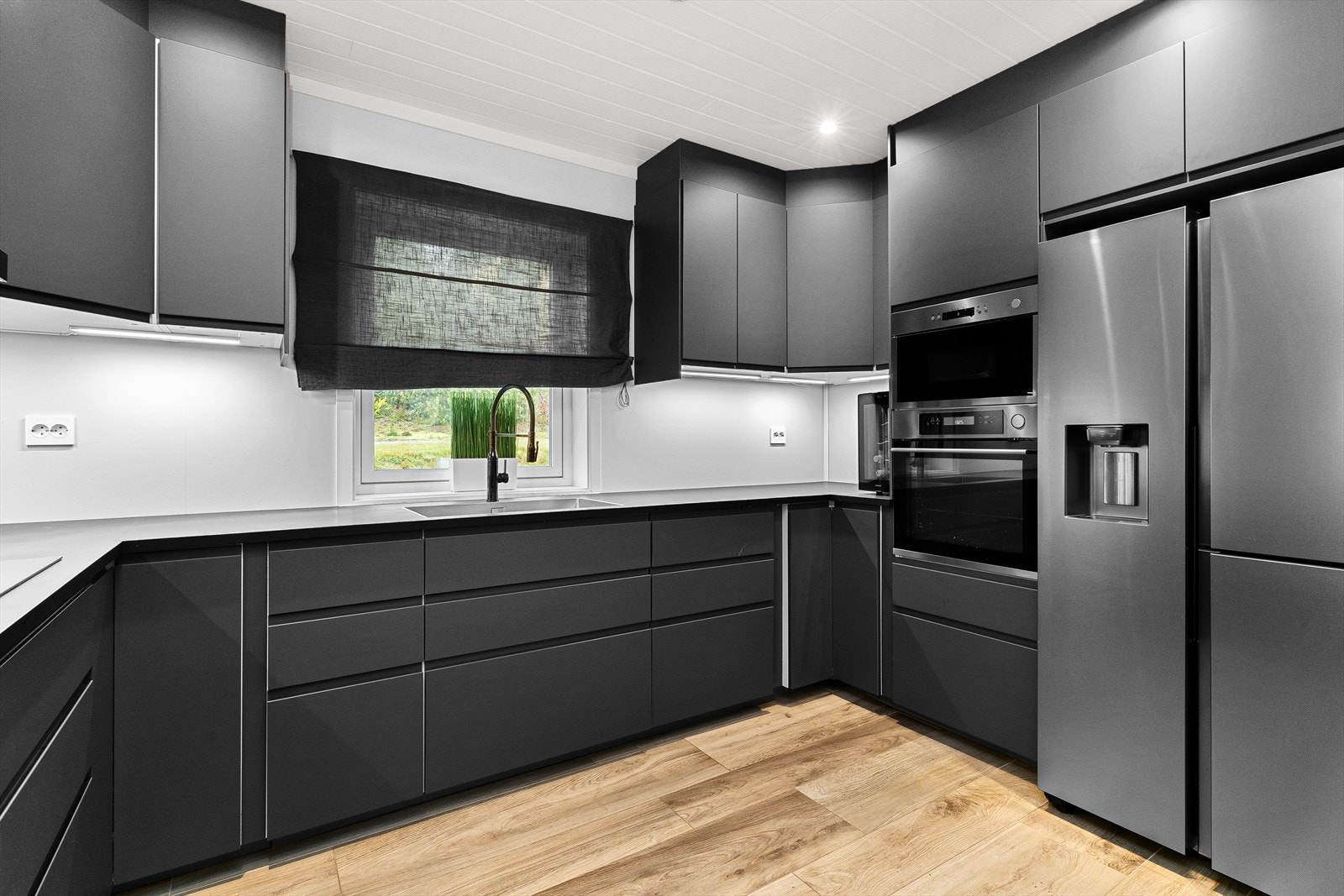 Moderne og tidsriktig kjøkkeninnredning i 1.etasje fra Ikea med mørke, slette fronter og benkeplate av laminat. Galleribilde