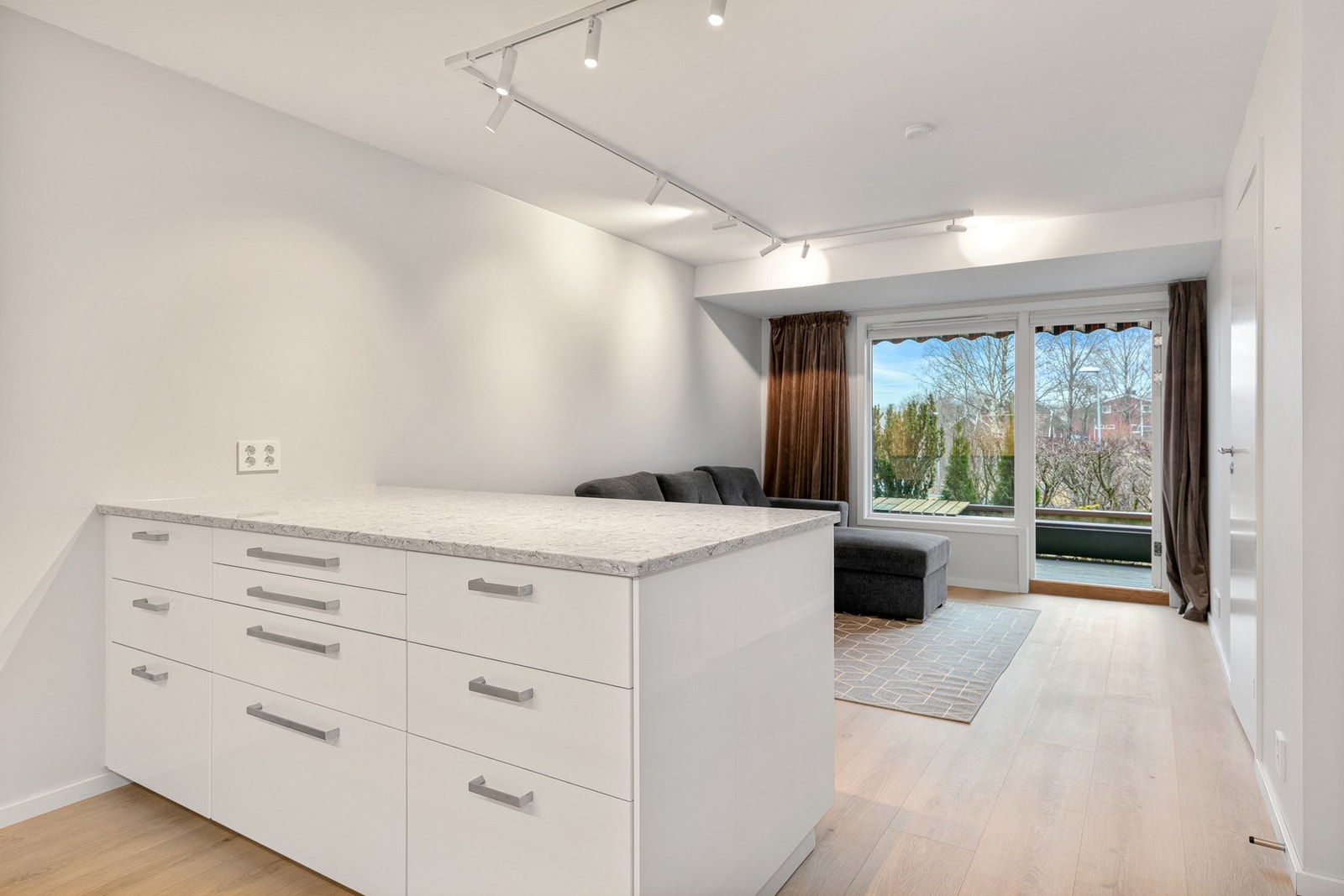 Mellom kjøkken og stuen er det en øy med skap og skuffer Galleribilde