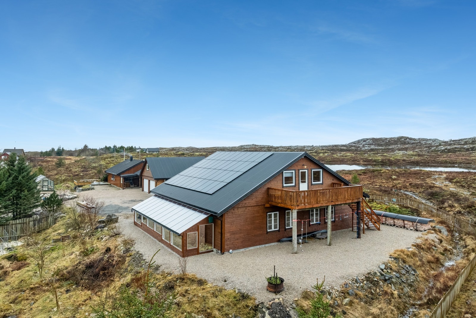 Romslig garasje/verksted, oppført i 2021 med et bruksareal på hele 263 kvm. Til venstre i bildet er det et stort drivhus Galleribilde