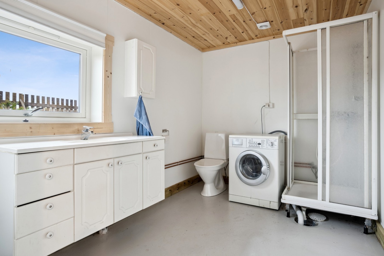 Badet i garasjen - Her finner man baderomsinnredning, dusjplass, toalett og vaskemaskin Galleribilde