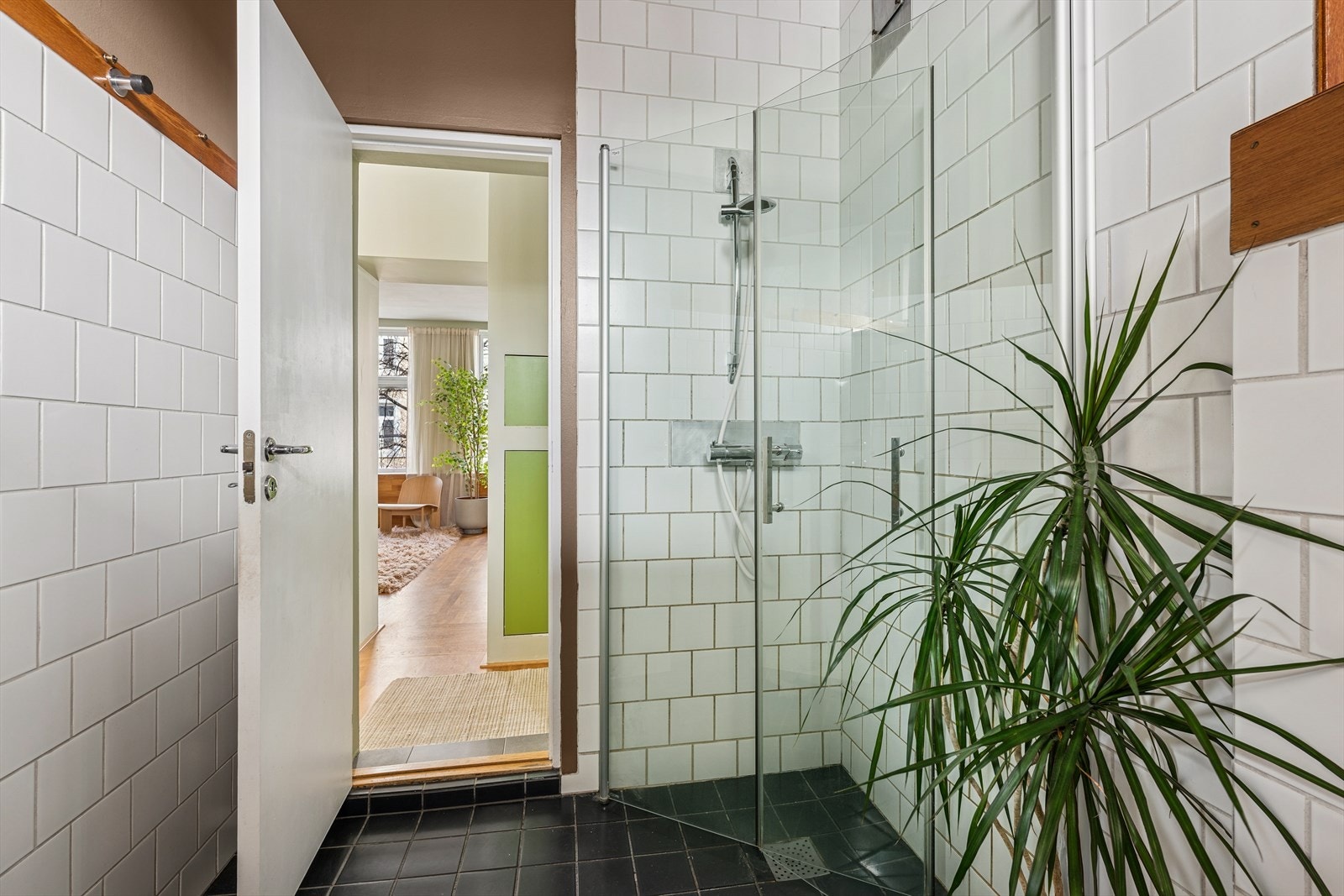 Badet inneholder vegghengt toalett, dusj og servant med to-greps blandebatteri samt opplegg for vaskemaskin Galleribilde