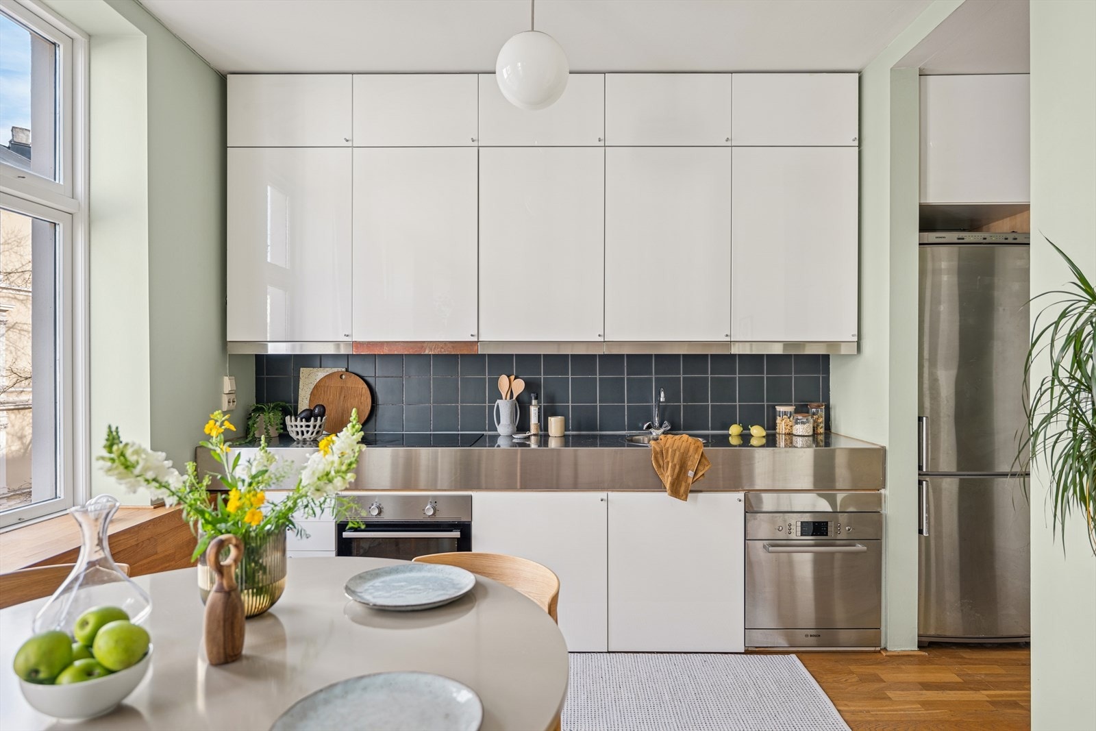 Kjøkkenet består av innredning med slette fronter, benkeplate i rustfritt stål, nedfelt oppvaskkum med ett-greps blandebatteri i tillett til integrert platetopp, komfyr, oppvaskmaskin og frittstående kjøl- og fryseskap Galleribilde