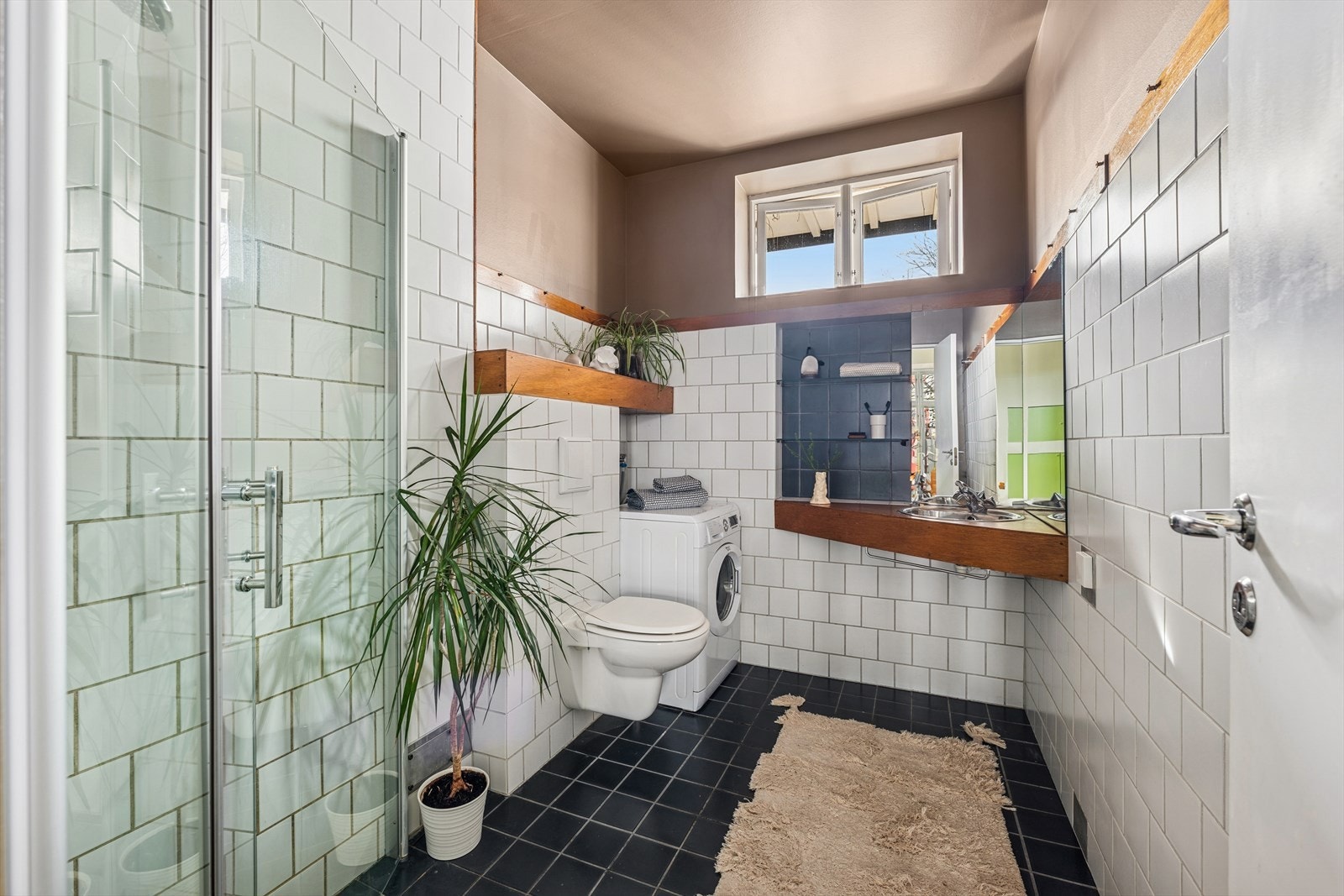 Stort, fliselagt baderom med delvis slette overflater på vegger og varmekabler i gulv Galleribilde