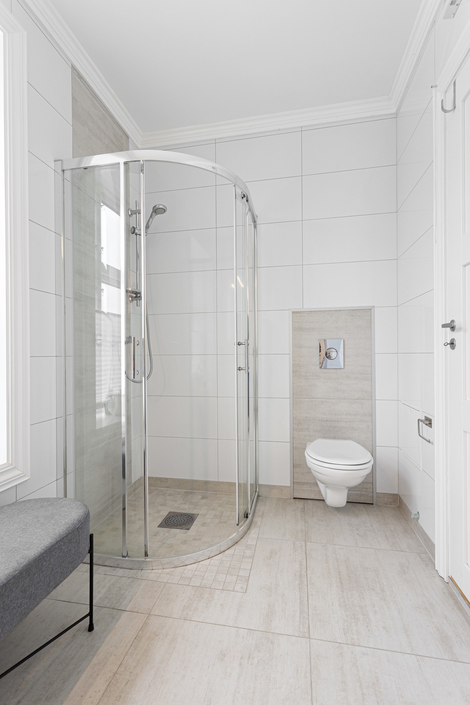 Badet består av vegghengt toalett, dusjkabinett, vegghengt vaske og opplegg til vasemaskin. Galleribilde