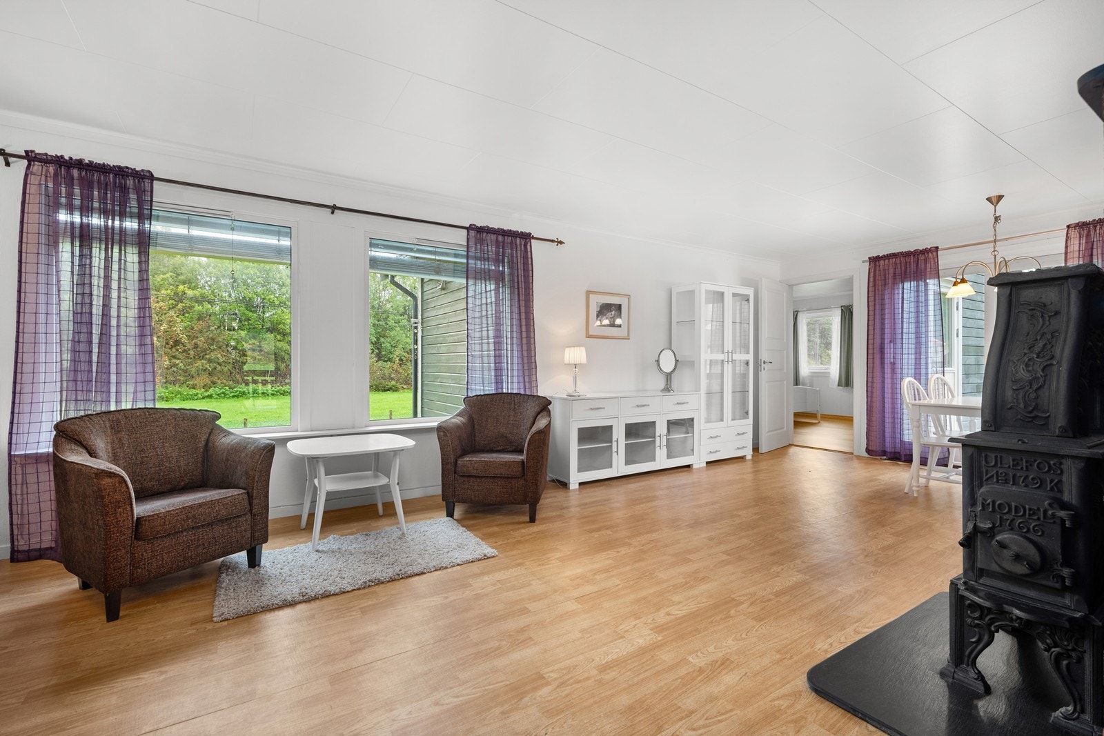 Boligen har en romslig og lys stue med vedovn Galleribilde