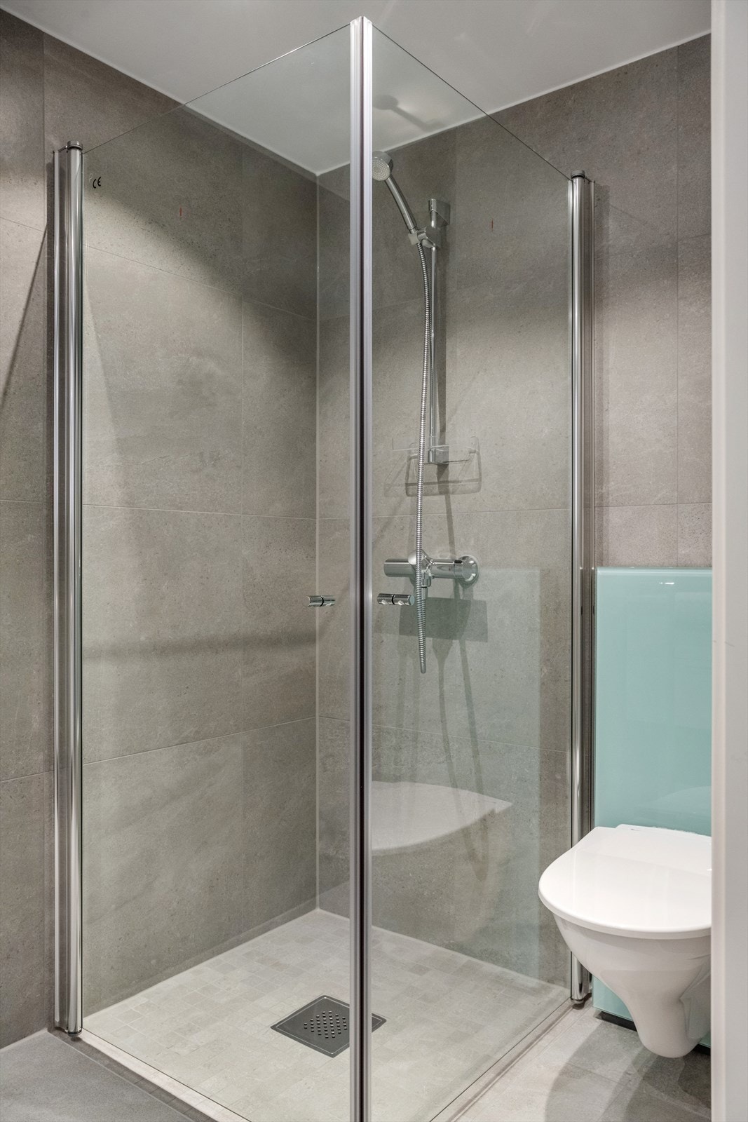 Dusjhjørnet er utstyrt med glassdører som kan foldes inn når de ikke er i bruk, slik at de tar opp minimalt med plass. Galleribilde